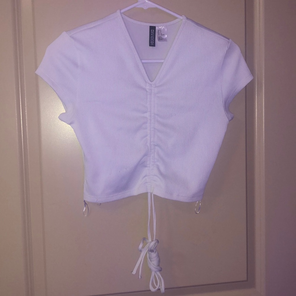 Crop top shirt with strings that wrap around waist.